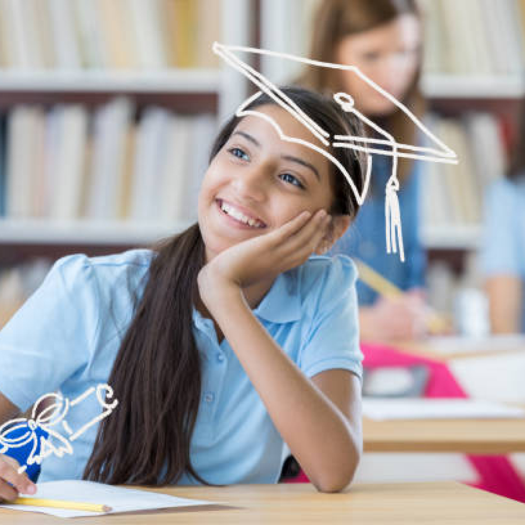 Cute middle school student thinks about her future. She is smiling with her hand on her chin.